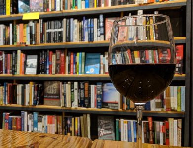 Glass of wine in front a bookcase for Cleveland Kids' Book Bank fundraiser