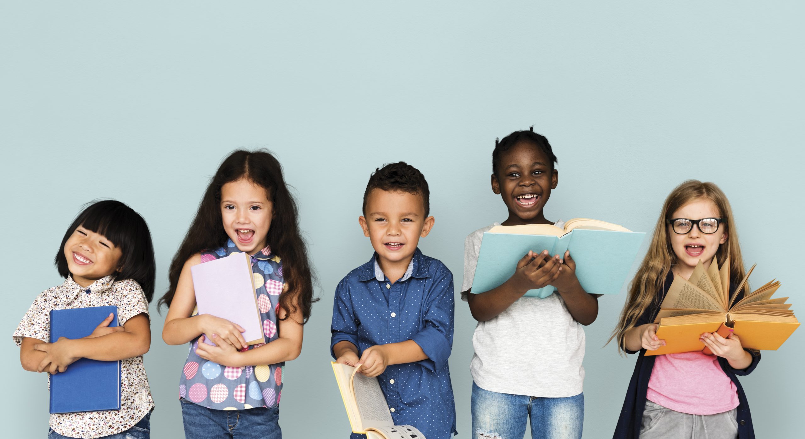 five children standing in a row holding books