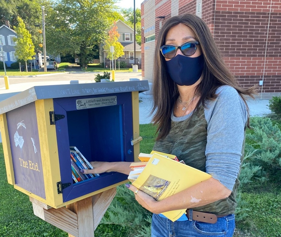 woman filling Little Free Library