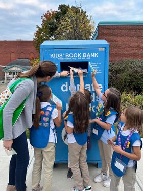 photo of large steel blue bin with Kids' Book Bank logo