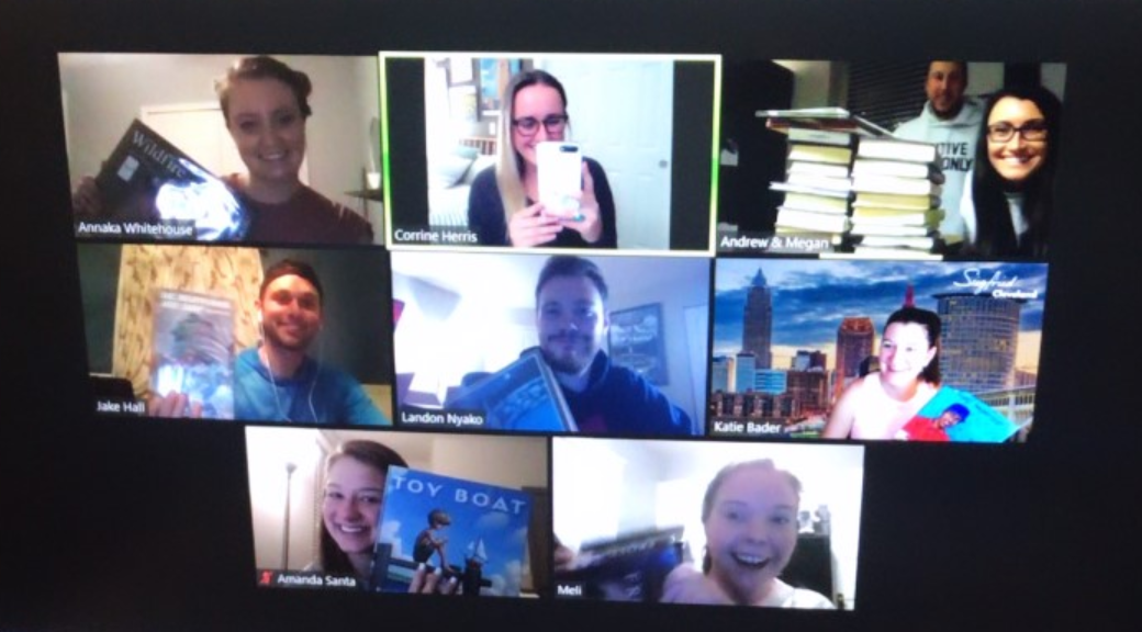 two women standing outside next to a cart full of boxes